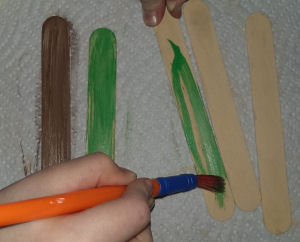 Painting popsicle sticks green and brown