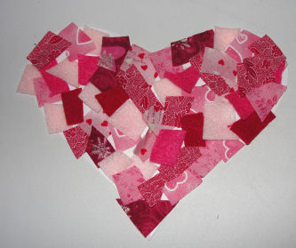 pink fabric squares cut up and placed onto a paper heart