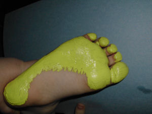 using yellow paint stamp a child footprint and turn it into a ducking photo