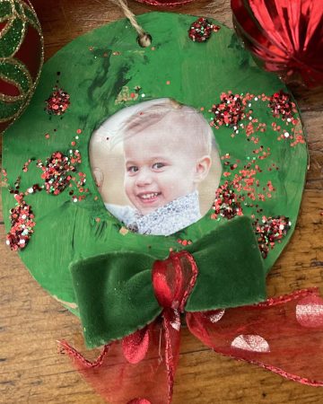 cardboard made into a wreath with a photo of a child on it